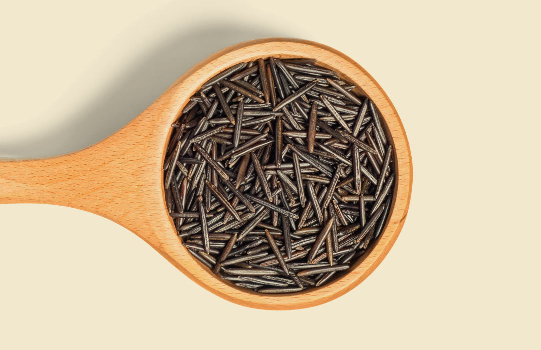 a wooden bowl full of whole grain wild rice